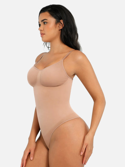 Woman wearing a beige bodysuit against a white background